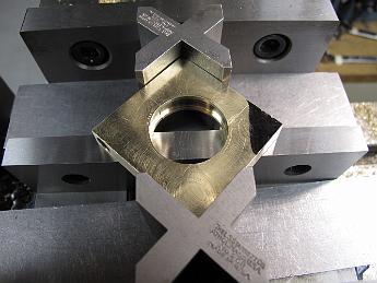 CrabWaterPumpModifications9Sept09 011 Clamping setup #1 to machine the ram mount--a failure.  This setup shifted the two halves of the strap, removing our ability to indicate the hole to find the center, which is needed for the next machining operation.  If you look closely, you can see parting line in the eccentric hole showing how the two parts have shifted.